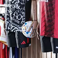 Different Football Team Jerseys Displayed On Mannequins And Hanging On Wooden Wall