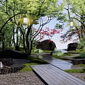 Natural Rockery Stones Landscape With Trees Hanging Lanterns Stone Slab Pathway And Rustic Cabin