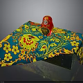 Table with Blue Yellow Floral Tablecloth and Traditional Red Matryoshka Doll