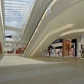 Modern Shopping Mall Interior With Glass Skylight Multi Level Walkways And Bright Storefronts