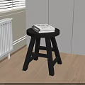 Black Round Side Table with Three Legs and Books on Wooden Floor Near White Cabinets