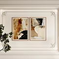 Framed Abstract Paintings on Decorative White Wall with Green Plant and Table Lamp