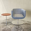 Blue Upholstered Leisure Chair With Round Metal Base And Wooden Side Table On Marble Floor
