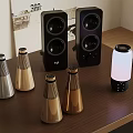 Various Stylish Speaker Devices With Gold Silver And Black Designs On Wooden Table