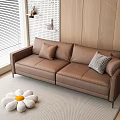 Two-seater Brown Sofa with Plaid Pillow and Flower Cushion on Gray Rug Wooden Wall