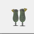 Two Tall Green Cocktail Glasses Filled with Ice Cubes and Lemon Garnish