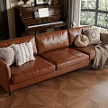 Brown Three Seater Leather Sofa With Pillows Throw Blanket And Window View Of Green Plants