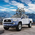 Blue Toyota Tacoma Truck With Bicycles On Roof Rack And Mountain Landscape