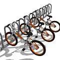 Three Silver Bicycles with Orange Wheels Parked at Metal Bicycle Rack