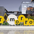 Outdoor Tomorrow Signage With Yellow White Letters Modern Building Background And Green Plants