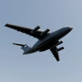 Large Military Transport Aircraft Flying in Clear Blue Sky with Four Engines