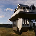 Modern Suspended Metallic Architectural Structure With Angular Roofs Over Grassland And Sky