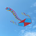 Red And Blue Kite Flying In Blue Sky With White Clouds And Colorful Streamers