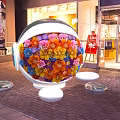 Decorative Spherical Structure Adorned With Colorful Flowers Near Storefront With Transparent Bases