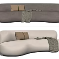 Modern Curved Multi Seater Sofa In Neutral Tones With Brown Pillows And Plaid Blanket
