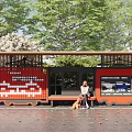 Modern Roadside Transit Bus Stop Shelter with Red Signage Bench and Pedestrian Waiting Area