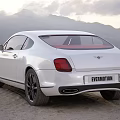 White Luxury Sports Car With Black Wheels Front Grille And Mountain Sky Background