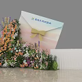 Envelope Shaped Art Installation With Colorful Floral Decorations And Yellow Bow