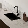 Modern Black Kitchen Faucet with Running Water Over Black Sink and White Marble Countertop