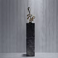 Decorative Ornament Set With Golden Sculpture On Black Marble Pedestal Against Gray Striped Wall