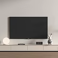 White TV Stand With TV Round Lamp Clock And Rabbit Decor Near Potted Plant