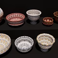 Colorful Ceramic Bowls and Vases with Intricate Decorative Patterns on Black Shelf