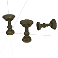 Three Bronze Candlesticks Displayed On White Background With Two Standing And One Overturned