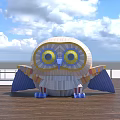 Large Colorful Cartoon Owl on Wooden Platform With Blue Sky White Clouds and Railing
