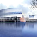 Modern Commercial Complex With Streamlined Glass Curtain Wall And Waterfront Reflection In Scenic Landscape