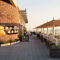 Delightful Dessert Shop With Red Brick Exterior Outdoor Seating Umbrella Canopies And Displayed Pastries