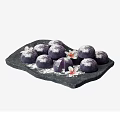 Purple Dessert Balls With Powdered Surface On Black Stone Platter And Flowers