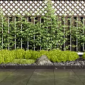 Green Garden Landscaping With Lattice Fence Shrubs Grasses And Stones On Dark Tiles
