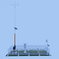 Weather Monitoring Station With White Picket Fence Tall Pole And Weather Vane