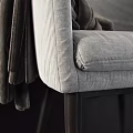 Gray Fabric Armchair With Brown Blanket Draped Over Armrest And Wooden Legs