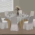 Round Dining Table Set with White Tablecloth Golden Skirt Six White Chairs and Flower Arrangement