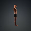 Man Standing Barefoot Shirtless in Black Shorts with Arms Outstretched Against Gray Background