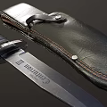 Tactical Metal Blade Knife With Black Stitched Leather Sheath And Textured Handle On Dark Surface