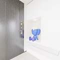 Blue Cartoon Like Sculpture With Big Eyes In Niche By White Cabinet And Black Door