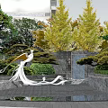 Residential Landscape With Bird Sculpture Water Feature Green Trees And Modern Building Stone Walls