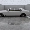 White Luxury Sedan with Black Wheels in Modern Indoor Space on Sleek Reflective Floor