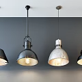 Four Industrial Style Pendant Lights With Metallic Shades And Illuminated Bulbs Hanging From Gray Ceiling
