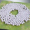 Many Baseballs in Circular Arrangement on Green Grass as Sports Equipment