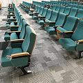 Modern Conference Room With Green Seats Wooden Armrests And World Map Screens