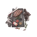 Grilled Steak on Black Slate Plate with Pepper Grinder Seasonings Knife Fork and Rosemary