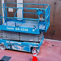 Blue Genie GS-3246 Scissor Lift Industrial Equipment on Red Ground with Orange Traffic Cones