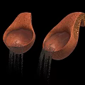 Brown Teardrop Shaped Objects With Textured Surface And Water Dripping Below