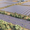 Industrial Solar Power Plant With Large Photovoltaic Panels Array Roads Vehicles And Greenery
