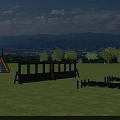 Outdoor Play Equipment on Green Lawn with Black Obstacles and Mountain View under Blue Sky