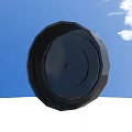 Black Circular Tire With Central Hub Against Blue Sky And White Ground