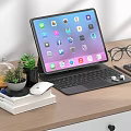 Tablet With Keyboard Mouse And Earbuds On Wooden Desk With Books Plant And Eyeglasses